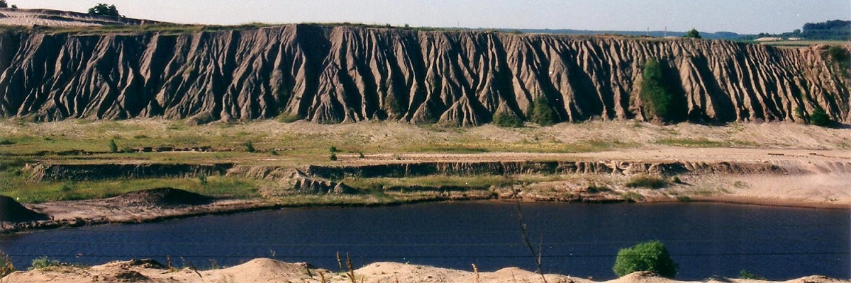 Bergbaufolgelandschaft in Niederlausitzer Landrücken: Bergbauabraumbauhalden vor einem wassergefüllten Restloch