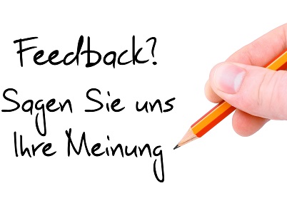 Schriftzug: Feedback geben! Sagen Sie uns Ihre Meinung (schwarze Schrift auf weißem Hintergrund) am rechten Bildrand eine Hand hält einen Bleistift