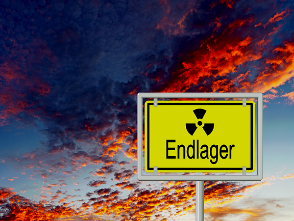 Ortsschild mit der Aufschrift Endlager für Atommüll vor einem sonnabendlichen Wolkenhimmel