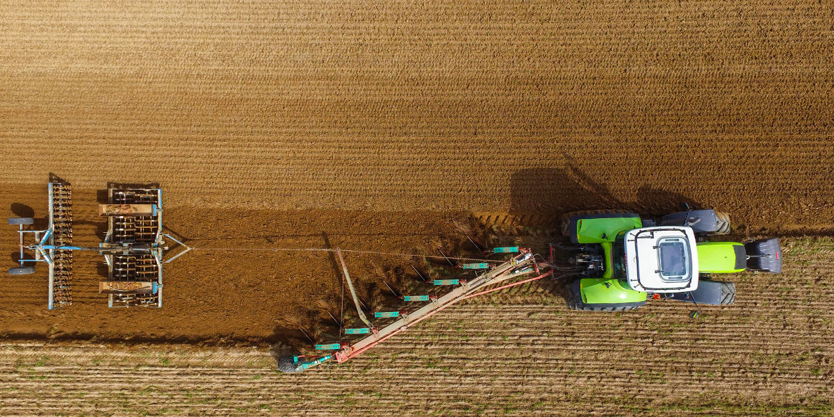 Bild: Ein Landwirt pflügt an einem Acker (Luftaufnahme mit einer Drohne).