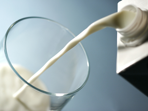 Milch wird in ein Glas gefüllt.