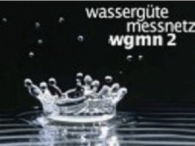 Schwarz-weiß-Bild: In der rechten oben Ecke ist der Schriftzug Wassergütemessnetz wgmn 2 zu lesen. Mittig  spritzt durch einen in Wasser gefallen Wassertropen etwas Wasser hoch.